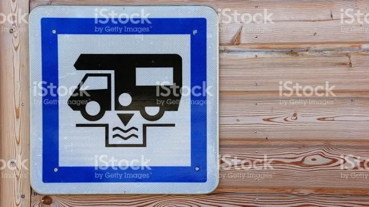 A blue dump point sign showing a camper emptying its waste tank