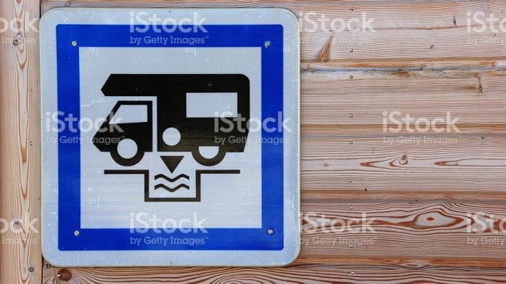 A blue dump point sign showing a camper emptying its waste tank