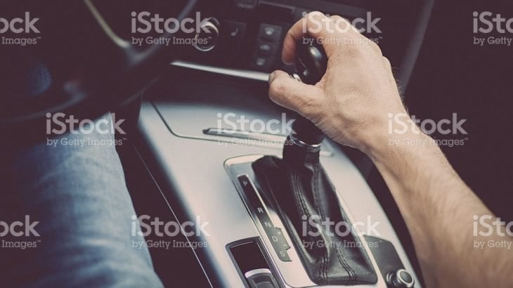 A driver's hand on an automatic transmission gear selector