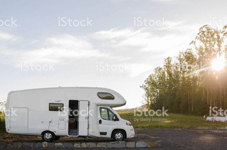 A motorhome parked with its door open at sunset