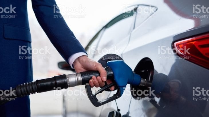 A person refuelling a car at a petrol station pump