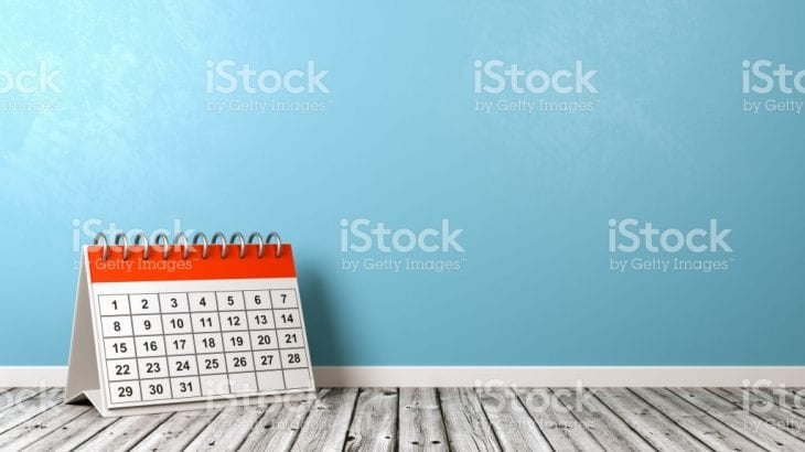 A desk calendar standing against a blue wall