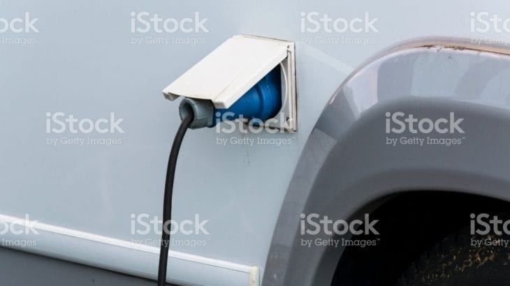 A power lead plugged into the external socket of a campervan