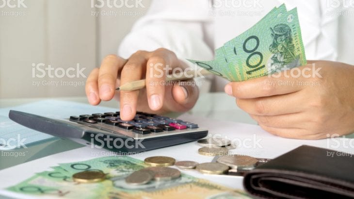 Accountant woman counting an australian money and using calculator for accounting concept.