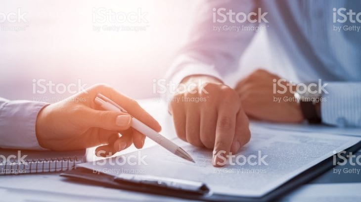 Business people negotiating a contract. Human hands working with documents at desk and signing contract.